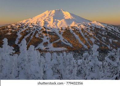 The snow covered Cascade Mountains and frozen trees at sunrise in winter
