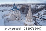 Snow covered city with a large church and a small church. The church is surrounded by a large courtyard. The ancient Russian city of Suzdal