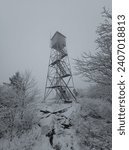 Snow covered firetower on an overcast day in Adirondack Park in NY