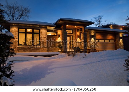 Snow covered front yard of modern house in Ontario Canada at twilight
