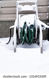 Snow Covered Garden Hose Ouside A House In Winter