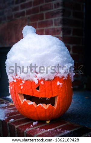 Snow covered Halloween carved pumpkin