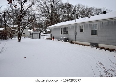 Snow Covered Houses In A Neighborhood In Kansas City, Missouri. One House Has Some Serious Icicles.