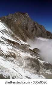 snow covered mountain with clouds