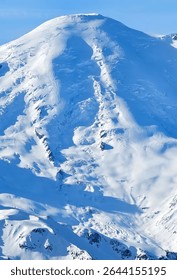 a snow covered mountain peak under a blue sky, a beautiful winter landscape view