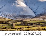 Snow covered mountains and green fields in Ireland