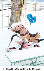 Snow Covered Outdoor Swing, Ladder And Bouncy Horse