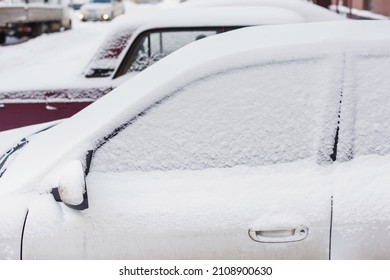 Snow Covered Parked Car After Snowfall. Many New White Snow On A Dirty Car. Close Up Of Cars Side View. Door, Window, Handle And Mirror