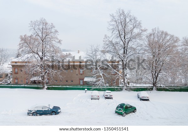 Snow covered\
parking lot, cars under, from above\
