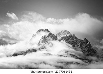 Snow covered peaks of the Sesto Dolomites in clouds, mountains of the Alps, black and white photo, South Tyrol, Italy, Europe