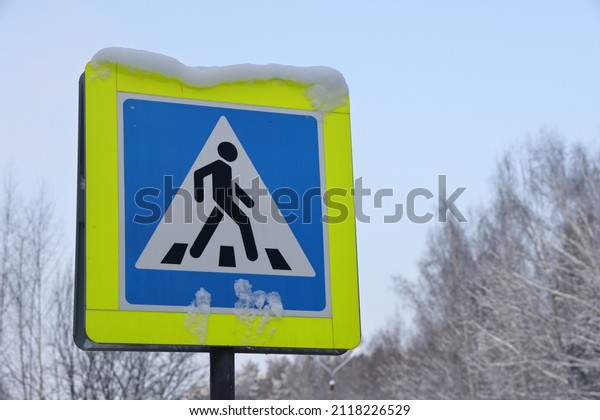Snow covered road pedestrian sign. It was\
snowing in the city.\
Close-up