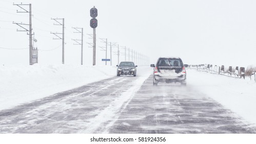 Snow covered road, winter driving with sign - slippery