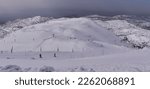 Snow covered ski pistes for skiing and snowboarding as seen from the upper cable car station, Mount Hermon Ski resort, the Golan Heights, Israel.