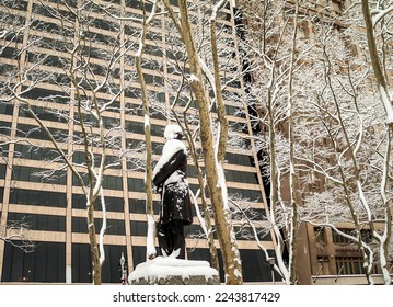 The snow covered statue of William E Dodge in Bryant Park in Manhattan.