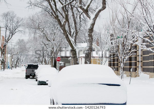 Snow covered vehicle in Canadian city during a\
harsh winter
