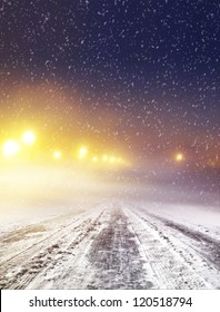 Snow Covered Winter Road With Shining Streetlights At Night