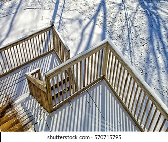 Snow Covered Wooden Steps To A Deck On A House.