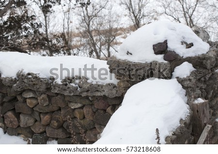 Snow covers the stone fence at Phelps Park in Decorah, IA, USA.