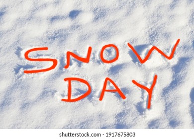 SNOW DAY Written In Bright Red Capital Letters In Fresh Snowfall Signifies No School And School Closure Due To Dangerous Weather Conditions.