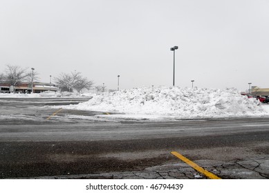 A Snow Drift In A Parking Lot.