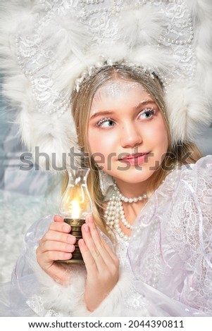 snow fairy in the forest holds a lamp with fire in her hands. fabulous decoration