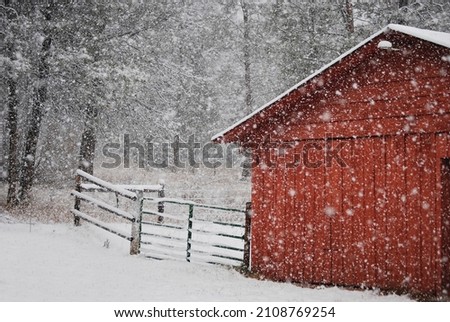 Snow falling against Red Barn
