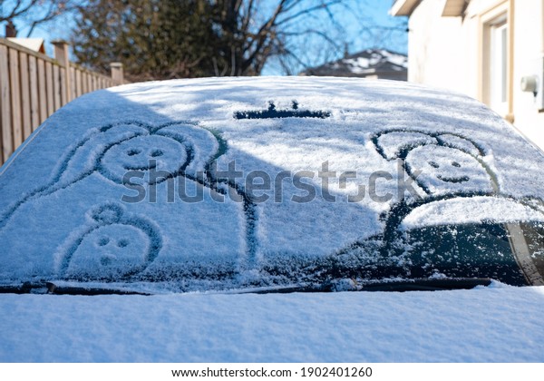 Snow finger drawing on a car. It\'s a freezing\
cold winter in Toronto.