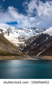 Snow And Glaciers Melt In The Mountains And Fill A Reservoir (in This Case The Lac De Grand Maison In The French Alps  In The Isère Region)