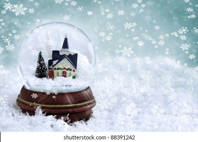 Snow Globe With Church And Christmas Trees Inside. Copy Space Available. Shallow Depth Of Field With Selective Focus On Snowglobe.