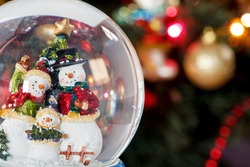 Snow Globe With Happy Snowman Family On Christmas Tree Blured Background