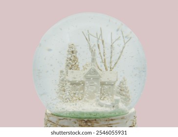 A snow globe with a house and trees on a pink background - Powered by Shutterstock