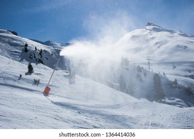 Snow gun in action, overlapping of ski slopes with artificial snow