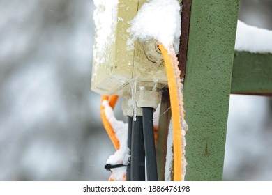 Snow And Ice Covered Socket And Cables. Snow-covered Electrical Cables. Outdoor Socket