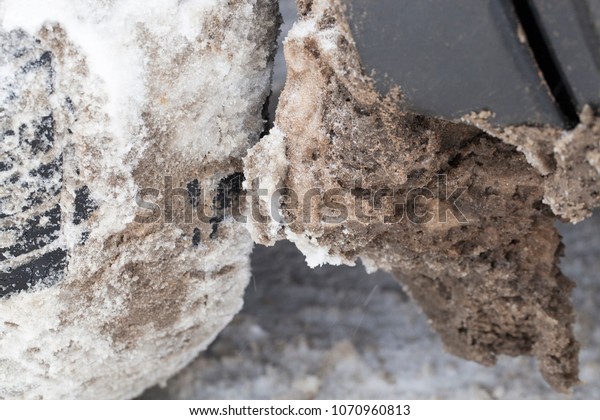 snow and ice dirty adhered to the car in the winter\
season, Photo close up