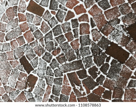 Snow and ice emphasize the distinct patterns in brickwork.