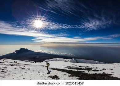 Snow, ice and glaciers on top of mount Kilimanjaro at sunrise with clouds in the sky background, Africa