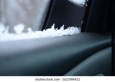 Snow And Ice Are On A Car Door Window Seal.