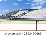 Snow melting off solar panels outfitted with snow guards at a local community centre and hockey rink in Calgary Alberta Canada