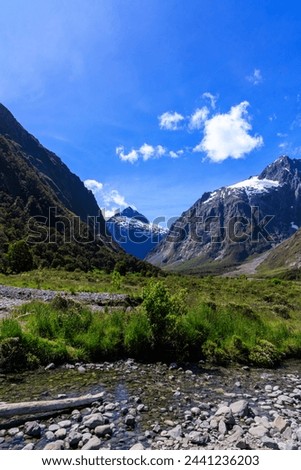 snow montain and small river near milfordsound with blue sky in fine day in summer