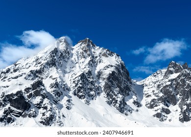 Snow mountain top blue sky clouds with prayer flags. Mountain peaks on a clear blue day. Snow covered mountain peaks. Snow covered mountain tops with clear blue sky background. - Powered by Shutterstock