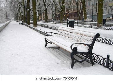 Snow On Bench In Park Of Winter.