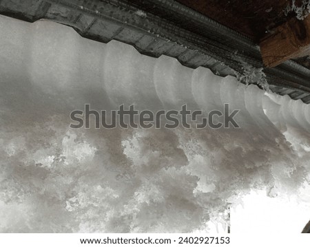 Snow on a metal roof. Snow sliding from the roof during the thaw. Danger of falling snow in winter.