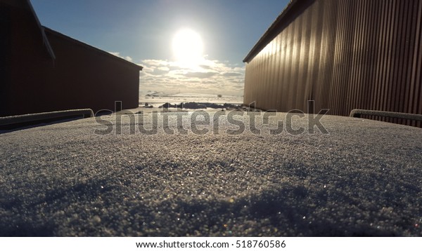 Snow on top of a car\
in the sun landscape
