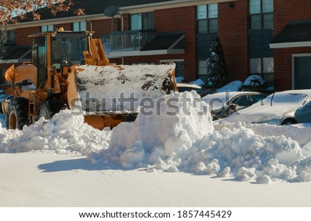 Snow plough truck clearing road after winter snowstorm blizzard for vehicle access