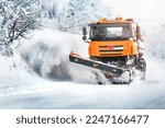 Snow plough truck on snowy road in action. Powing winter road 