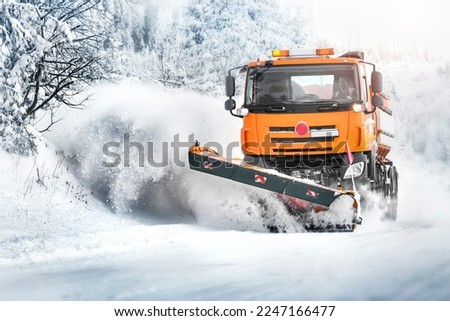 Snow plough truck on snowy road in action. Powing winter road 