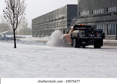 Snow Plow Cleaning Up The Parking Lot.