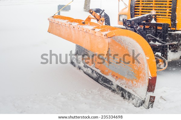 Snow plow doing snow removal after a blizzard in\
Chicago suberb.