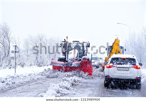 Snow plow makes traffic\
jam in winter.