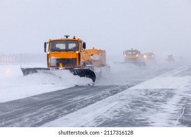 Snow plow on the runway in a snowstorm - Powered by Shutterstock